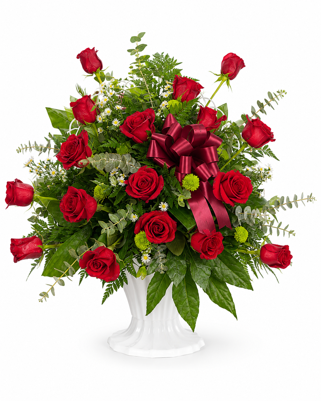 Red rose sympathy flower arrangement with fillers and greenery in a white pedestal urn. White background