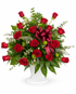 Red rose sympathy flower arrangement with fillers and greenery in a white pedestal urn. White background