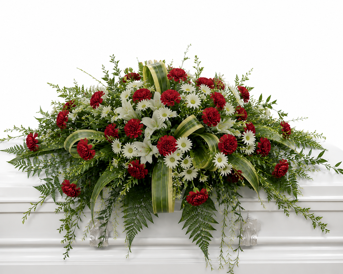 A full-size garden-inspired casket spray featuring an abundant arrangement of premium seasonal flowers surrounded by lush greenery and flowing foliage. The natural cascading design creates a peaceful, elegant tribute that symbolizes love, remembrance, and everlasting respect, making it ideal for funeral services and celebrations of life.