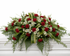A full-size garden-inspired casket spray featuring an abundant arrangement of premium seasonal flowers surrounded by lush greenery and flowing foliage. The natural cascading design creates a peaceful, elegant tribute that symbolizes love, remembrance, and everlasting respect, making it ideal for funeral services and celebrations of life.