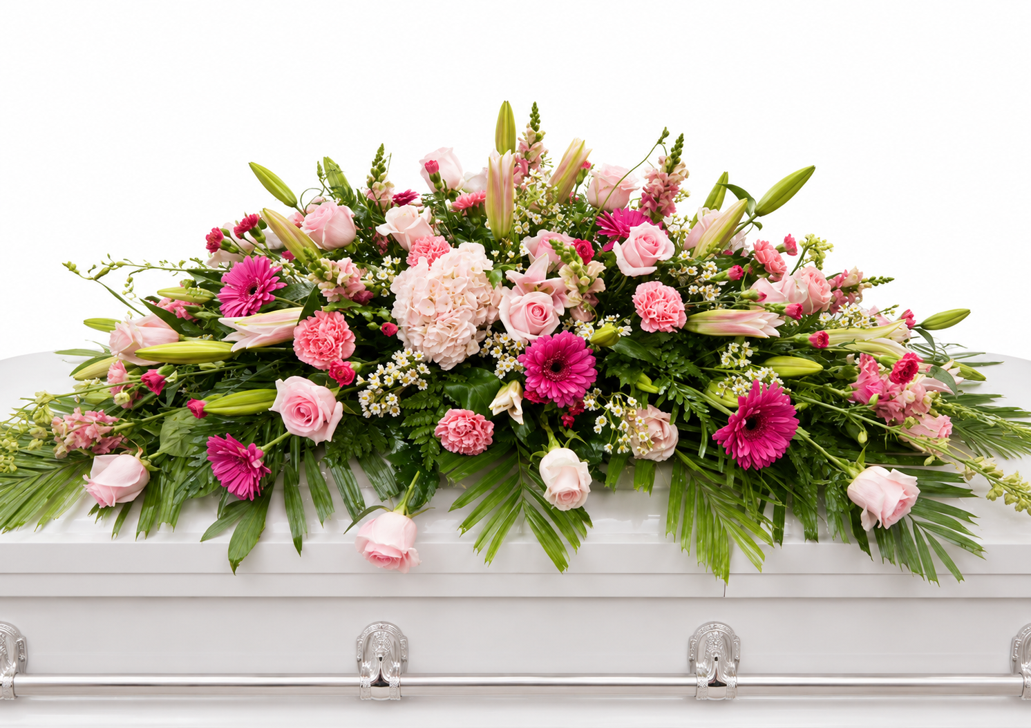 Graceful pink casket spray featuring soft pink roses, pink gerbera daisies, pale pink carnations, delicate filler flowers, and flowing greenery, arranged in a full, elegant design atop a white casket in a softly lit chapel setting.