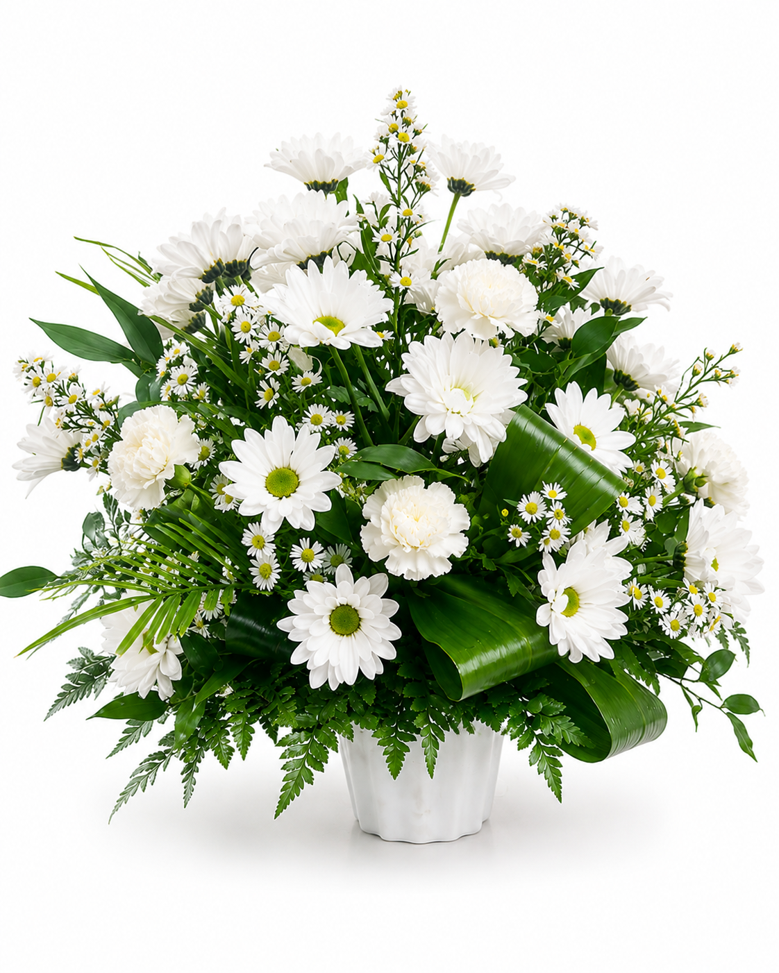 A white and green floral arrangement featuring white daisies, carnations, and asters in a white basket with aspidistra leaves, set against a plain white background.