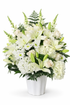 Classic white sympathy arrangement featuring white lilies, ivory roses, white hydrangea, white daisies, and lush fern greenery, designed in a full, elegant style and displayed in a white urn against a clean white background.