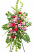 Vibrant standing sympathy spray featuring red and pink roses, pink lilies, bells of Ireland, soft pink filler flowers, and cascading palms, arranged in a lush vertical design on a green easel against a clean white background.