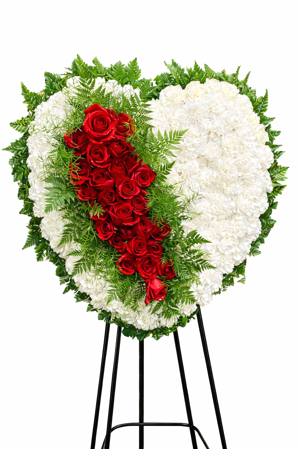 Heart-shaped sympathy wreath featuring white carnations accented with a cascading ribbon of deep red roses and lush greenery, arranged in a bold, elegant design on a green easel against a clean white background.