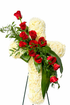 Cross-shaped sympathy arrangement made of ivory roses and white hydrangeas, accented with cascading red roses and lush green foliage, designed in a graceful, traditional style and displayed on a green easel against a white background.