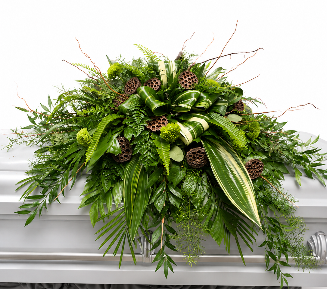 A contemporary woodland-inspired casket spray featuring layers of lush tropical greenery, variegated foliage, leatherleaf fern, green spider mums, lotus pods, curly willow branches, and flowing botanical accents arranged in a natural cascading design. The rich green palette creates an elegant and peaceful tribute that celebrates a life connected to nature and the outdoors.