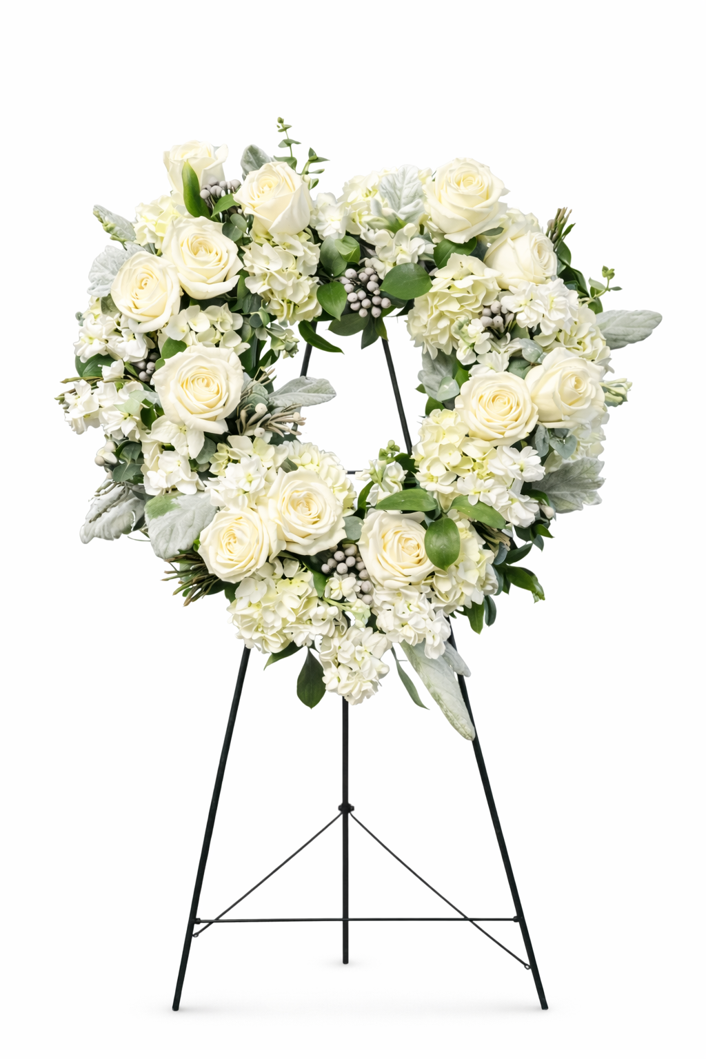 Elegant white sympathy open heart wreath featuring ivory roses, white hydrangea, soft textured greenery, and subtle berry accents, arranged in a classic heart design on a green easel against a neutral background.